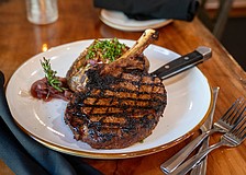 A perfectly seared cowboy ribeye — one of B&B's signature cuts — served with a loaded baked potato and bourbon-lacquered flair.