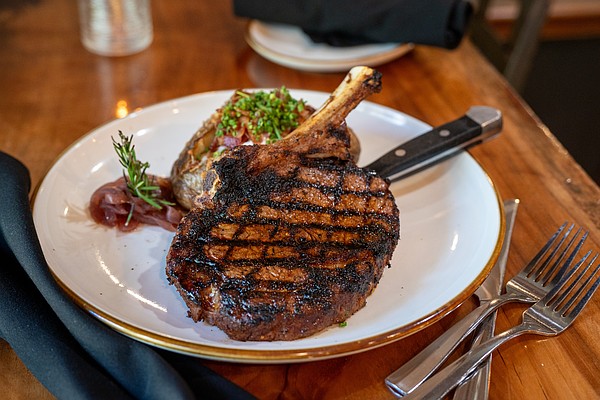 A perfectly seared cowboy ribeye — one of B&B's signature cuts — served with a loaded baked potato and bourbon-lacquered flair.