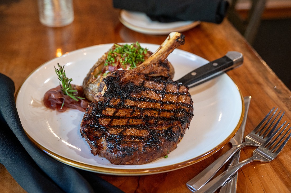 A perfectly seared cowboy ribeye — one of B&B's signature cuts — served with a loaded baked potato and bourbon-lacquered flair.