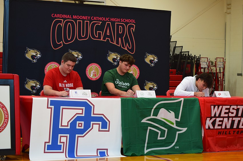 Max Polivchak (left), Ethan Salata (center) and Bryce Fulda (right) officially sign with Presbyterian, Stetson and Western Kentucky, respectively, on Dec. 3 at Cardinal Mooney Catholic High School.