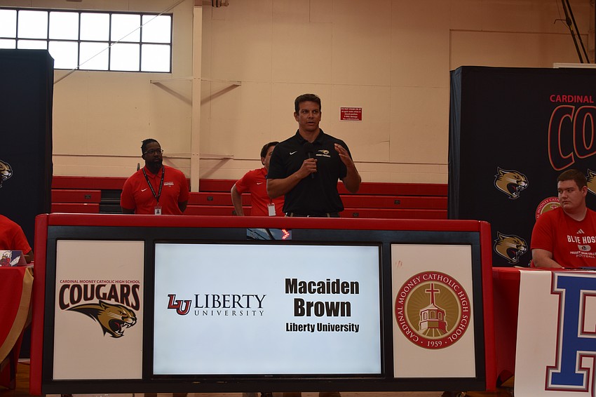Coach Jared Clark speaks to the audience at Cardinal Mooney Catholic High School about his team's group of early signees. The Cougars had seven total who are heading off to the Division I level.