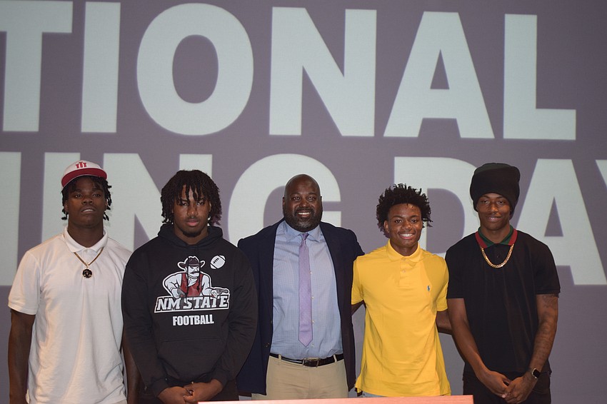 Coach Carlos Woods (center) poses for a photo with his group of signees on Dec. 3 at Booker's National Signing Day ceremony. From left: Kevontay Hugan, Jamaun Thompson, Dylan Wester and Chauncey Kennon.