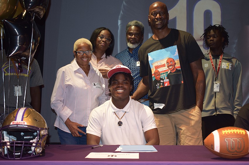 Kevontay Hugan smiles for a photo with his family after signing with Indiana. The four-star EDGE joins the Hoosiers, who as of Dec. 3, stand at 12-0 and ranked No. 2 in the country.