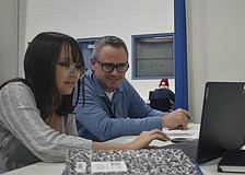 Eighth grader Mikayla Ross works with teacher Joseph Conner.