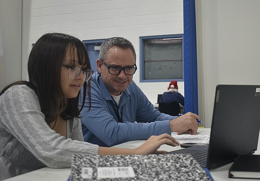 Eighth grader Mikayla Ross works with teacher Joseph Conner.