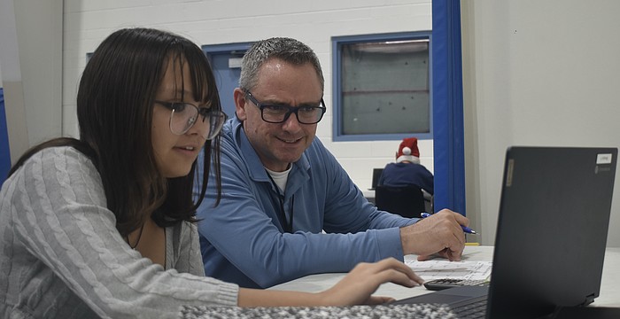 Eighth grader Mikayla Ross works with teacher Joseph Conner.