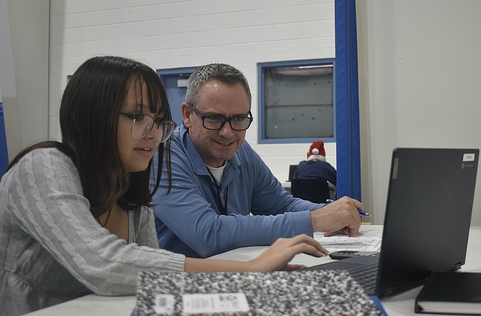 Eighth grader Mikayla Ross works with teacher Joseph Conner.