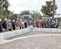 The first wave of participants in the Marie Selby Botanical Gardens groundbreaking scoop some sand.