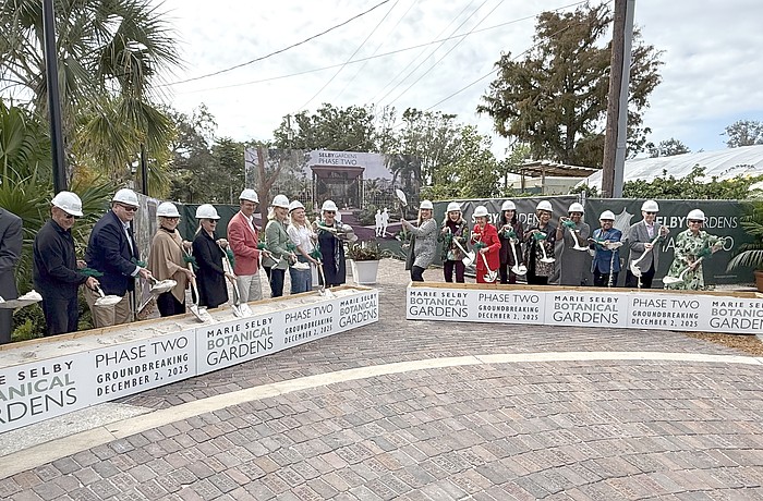 The first wave of participants in the Marie Selby Botanical Gardens groundbreaking scoop some sand.