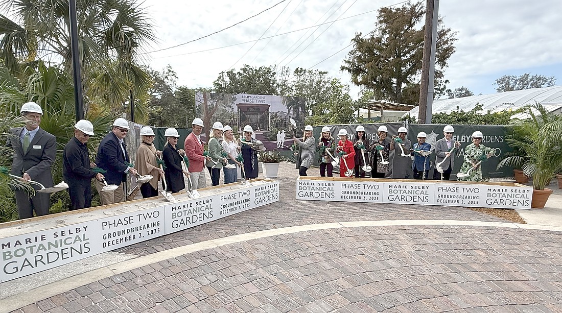 The first wave of participants in the Marie Selby Botanical Gardens groundbreaking scoop some sand.