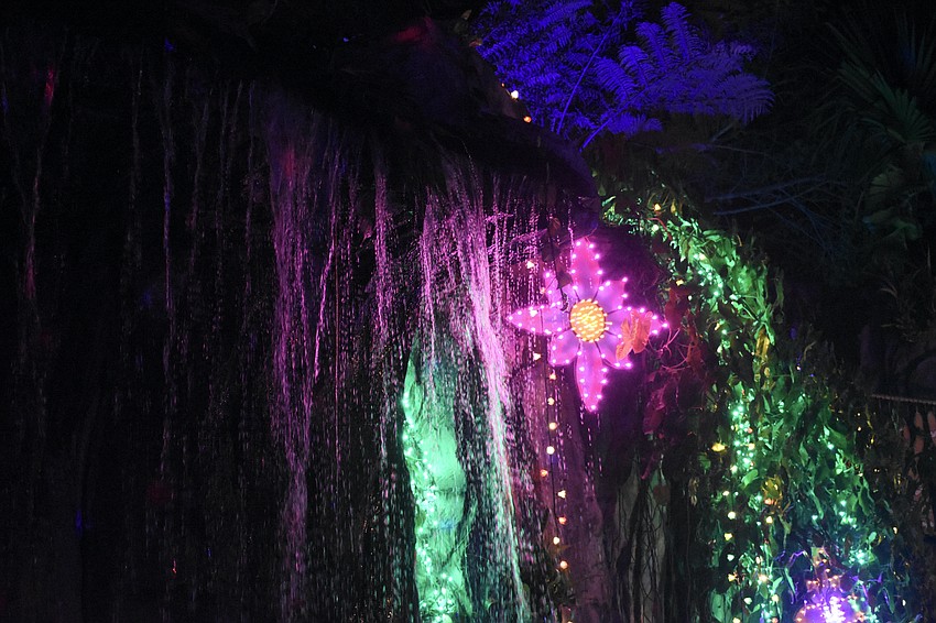 A waterfall cascades beside the decorations.