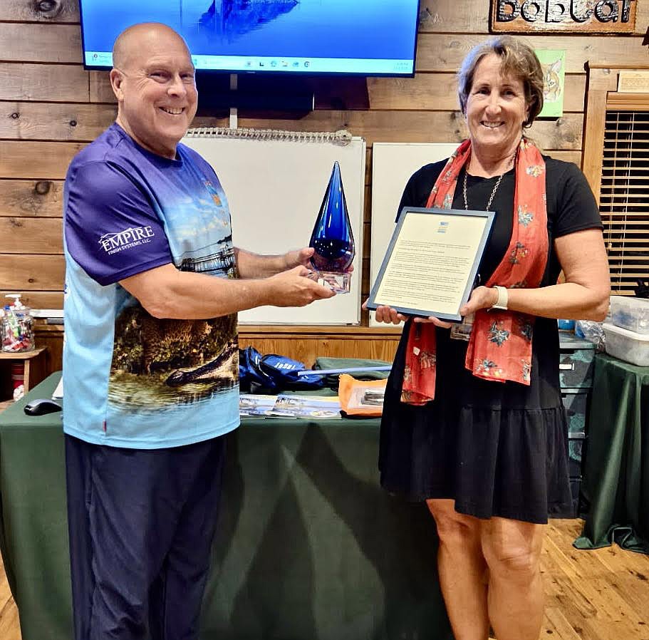 Joe Dunn, FOLA director and Liz Johnson smiling with the award.