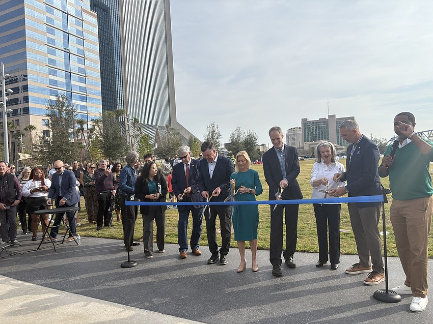 Officials prepare to cut the ribbon Dec. 5 to open Riverfront Plaza park.