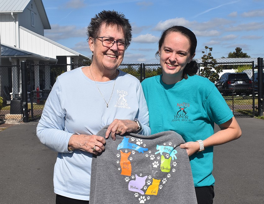 Nate's Honor Animal Rescue Center volunteer and donor Martha McKlveen received a personalized sweatshirt from Michaela Oglesby, a veterinarian at the shelter, in 2020. Now the same cats are honored on the walls of Kitty City.