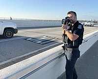 Sarasota Police Officer Michael Pietron uses a radar to check speeds on the Ringling Causeway.