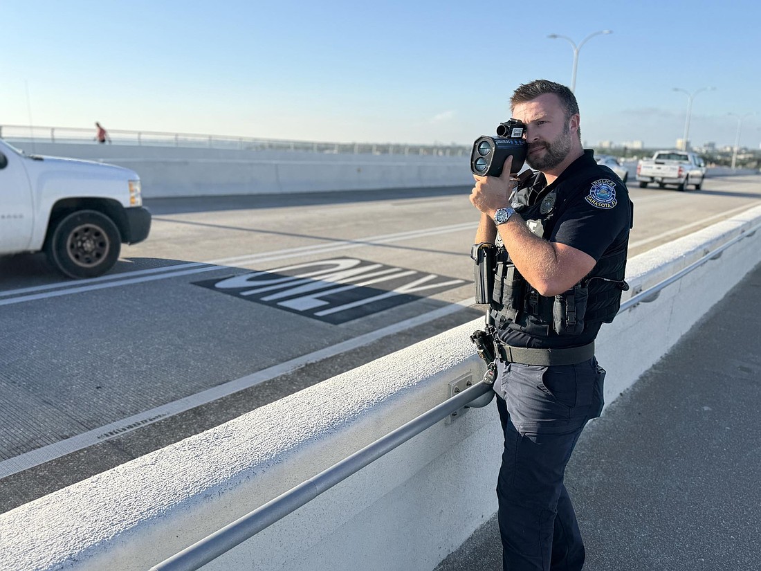 Sarasota Police Officer Michael Pietron uses a radar to check speeds on the Ringling Causeway.