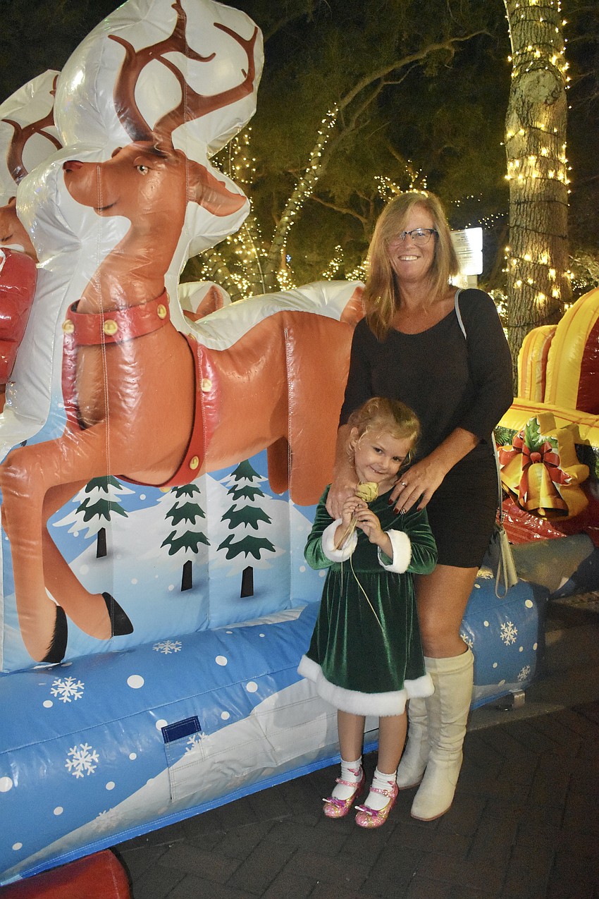 Teagan Rose, 4, and her grandmother Jean Anderson, stand by Santa's sleigh.