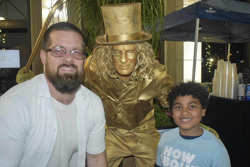 Living statue performer Joe Abel (center) poses with Wayne Liese and Levi Liese, 8.