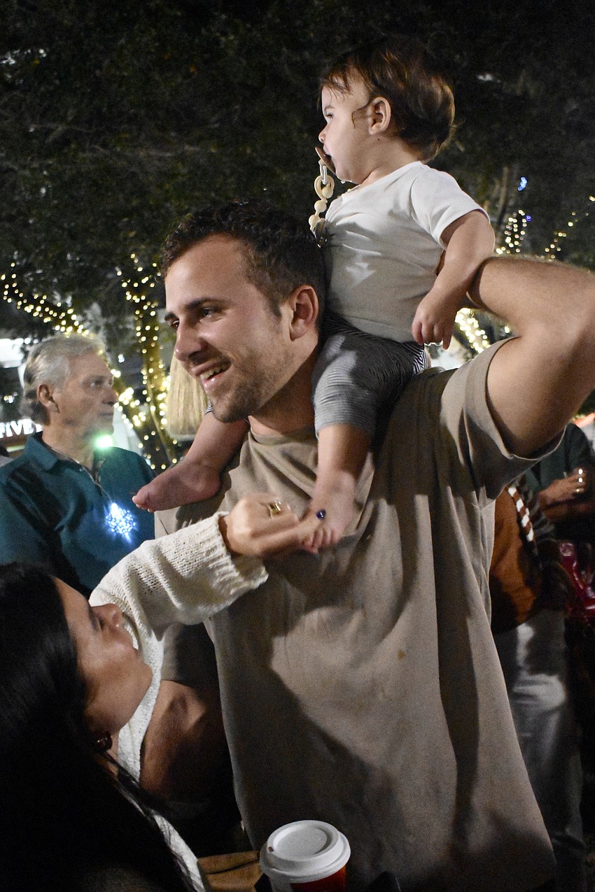 Lexi Zook, Justin Zook, and Zealand Zook, 1, await the tree lighting.