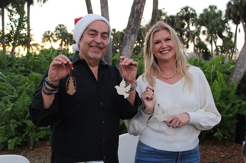 Fernando and Kelly Harb help families decorate ornaments at the Dec. 5 St. Armands Circle Christmas tree lighting.