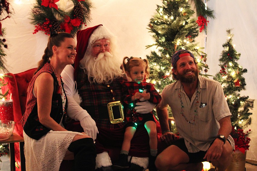 Sarah, Becca Rae and Cliff Talbott snap a family photo with Santa Claus at Holiday Night on the Circle. Two-year-old Becca Rae wished for a pony this year.