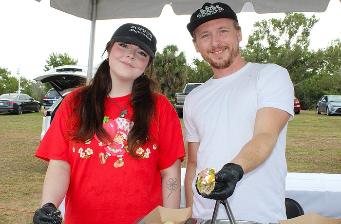 Emily Burns and Jack Coleman of Poppo's Taqueria dish up their popular pork tacos at the Kiwanis Club of Longboat Key's Lawn Party on Dec. 6 at Ken Thompson Park.