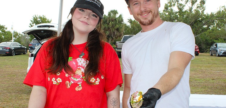 Emily Burns and Jack Coleman of Poppo's Taqueria dish up their popular pork tacos at the Kiwanis Club of Longboat Key's Lawn Party on Dec. 6 at Ken Thompson Park.