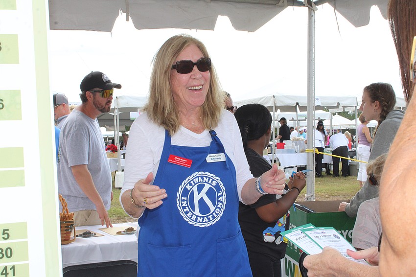 Kiwanian and Children's Guardian Fund board member Marlis Carter helps sell 50/50 raffle tickets for one the Lawn Party's main fundraiser activities.