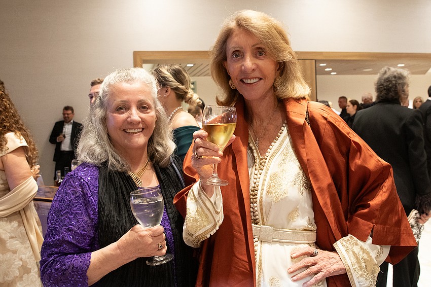 Nancy Holmes and Anne Parsons peruse the silent auction tables.