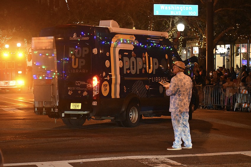 Danny Bilyeu, president of Sarasota Holiday Celebration Inc., watches as the Pop-Up Library enters the parade.
