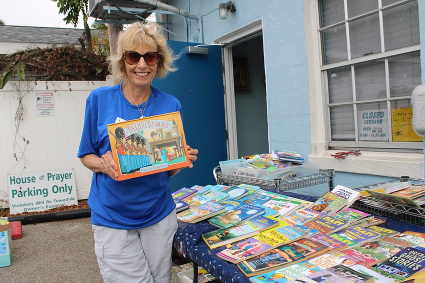Stillpoint Mission's Linda Troxler helped young readers pick out books at the annual holiday giveaway.