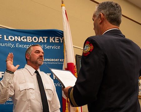Rev. Brock Patterson raises his right hand as he is sworn in as Longboat Key Fire Rescue’s second ever chaplain at the department’s awards ceremony Thursday, Dec. 4.