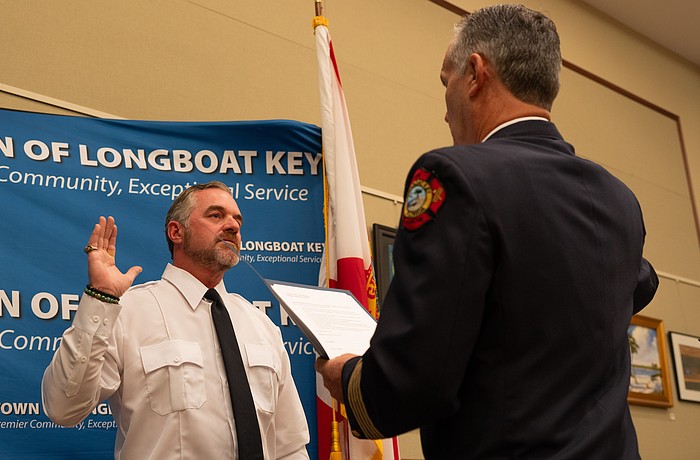 Rev. Brock Patterson raises his right hand as he is sworn in as Longboat Key Fire Rescue’s second ever chaplain at the department’s awards ceremony Thursday, Dec. 4.