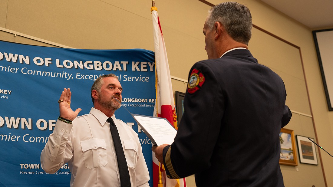 Rev. Brock Patterson raises his right hand as he is sworn in as Longboat Key Fire Rescue’s second ever chaplain at the department’s awards ceremony Thursday, Dec. 4.