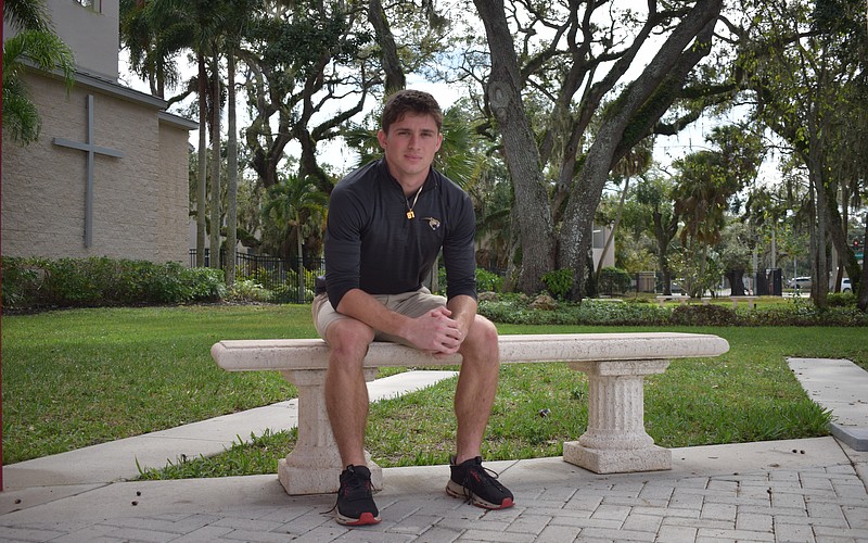 Mason Jordan poses for a photo on Dec. 8 outside the entrance to Cardinal Mooney Catholic High School. The slot receiver is in his fourth and final season on varsity and is the second-leading pass-catcher for the Cougars.