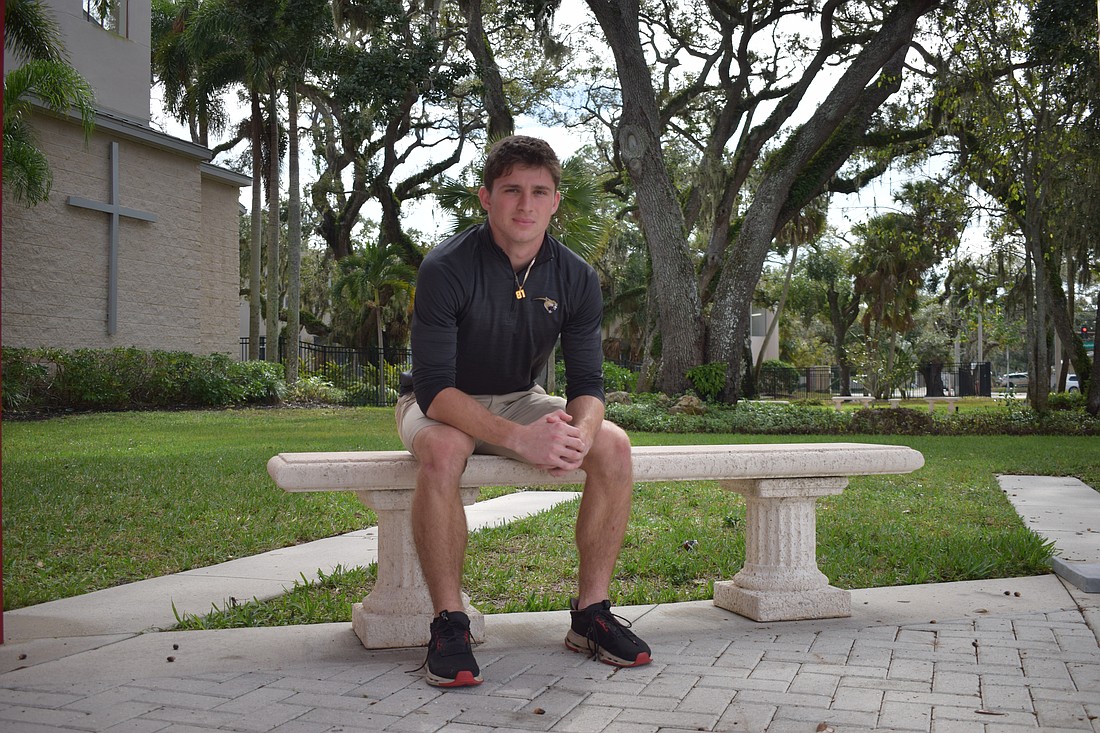 Mason Jordan poses for a photo on Dec. 8 outside the entrance to Cardinal Mooney Catholic High School. The slot receiver is in his fourth and final season on varsity and is the second-leading pass-catcher for the Cougars.