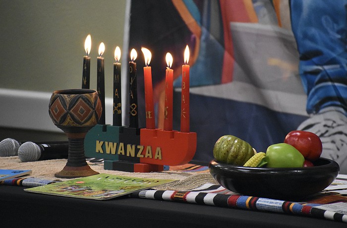 A Kwanzaa display rests on the table during the event.