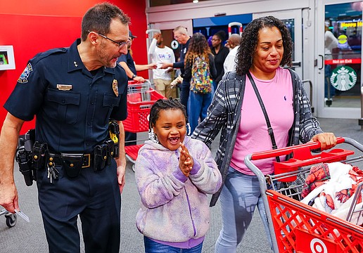 Sarasota Deputy Police Chief Scott Mayforth delights a young shopper at a previous Shop with a Cop event.