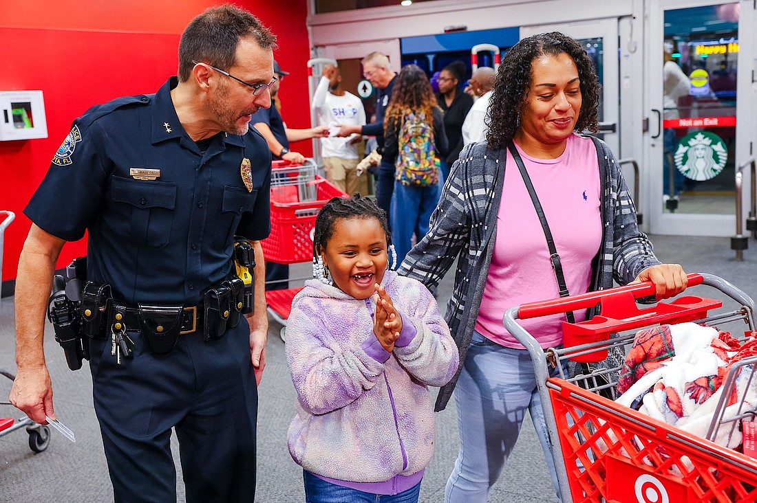 Sarasota Deputy Police Chief Scott Mayforth delights a young shopper at a previous Shop with a Cop event.