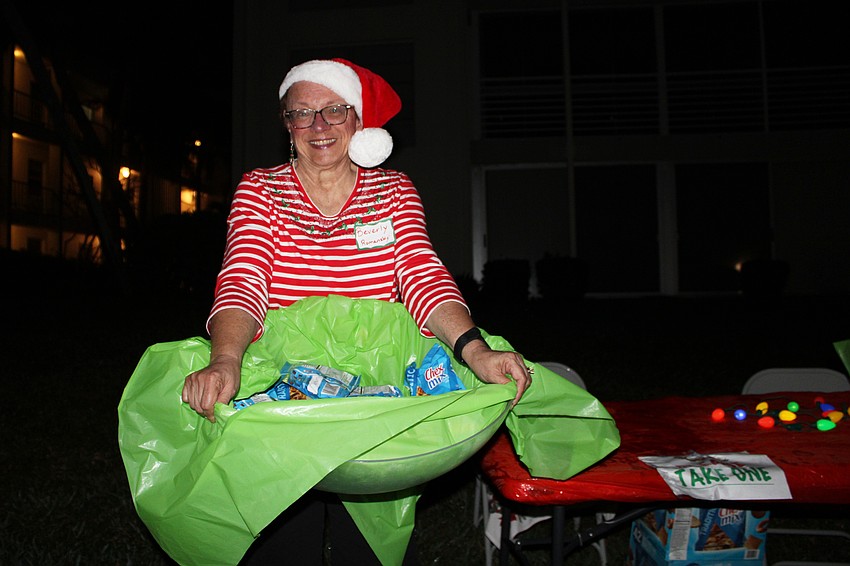 Beverly Romansky, whose team won first place at the 2025 Lighting of the Docks, hands out snacks along the parade route.