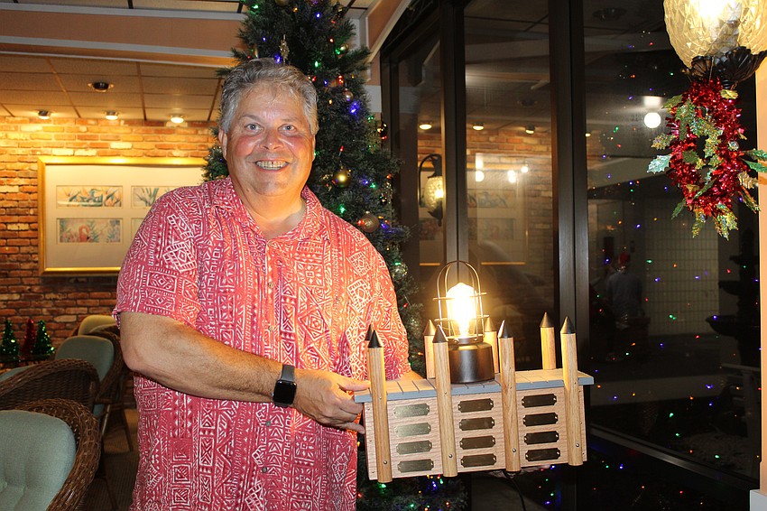 Commodore Jeff Hecklau showcases the custom trophy that will display the name of the winners of this year's Lighting of the Docks on Longboat Harbour.