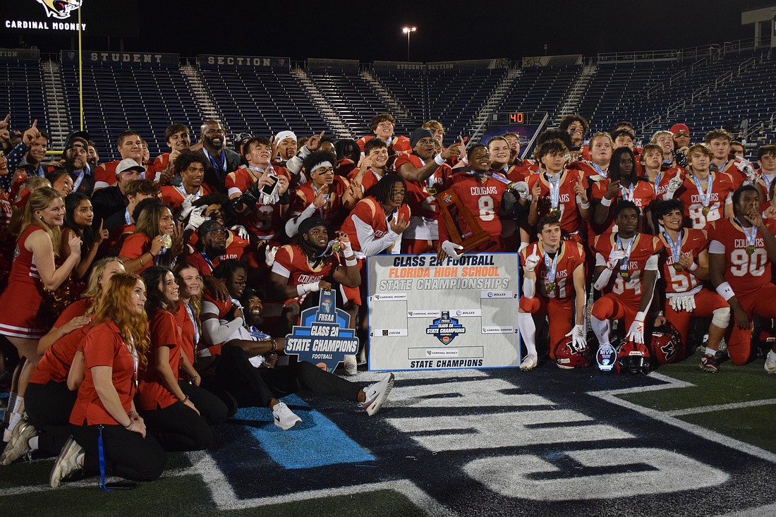 Cardinal Mooney football gathers at midfield and poses for a photo. The Cougars scored on every single one of their drives in the FHSAA Class 2A state championship, piling up 52 points against the Bulldogs.