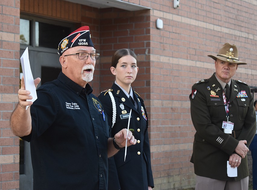 Dave Daily, post commander for VFW Post 12055, prepares to give $100 checks to the five winners in the Braden River JROTC alongside Brinlee Johnson, a senior and the battalion commander and Michael Massmann, senior army instructor.