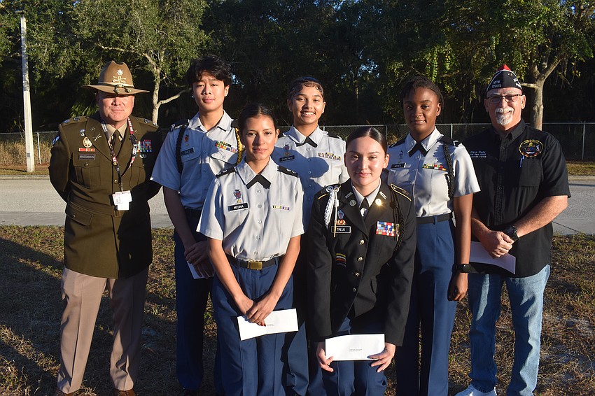 Braden River High School JROTC senior army instructor Michael Massmann and students Tuong Thai, Karla Medina, Mystique Quinones, Marfil Trejo and Wilendjie Medea meet with Dave Daily, post commander for VFW Post 12055, to celebrate their winning essays.