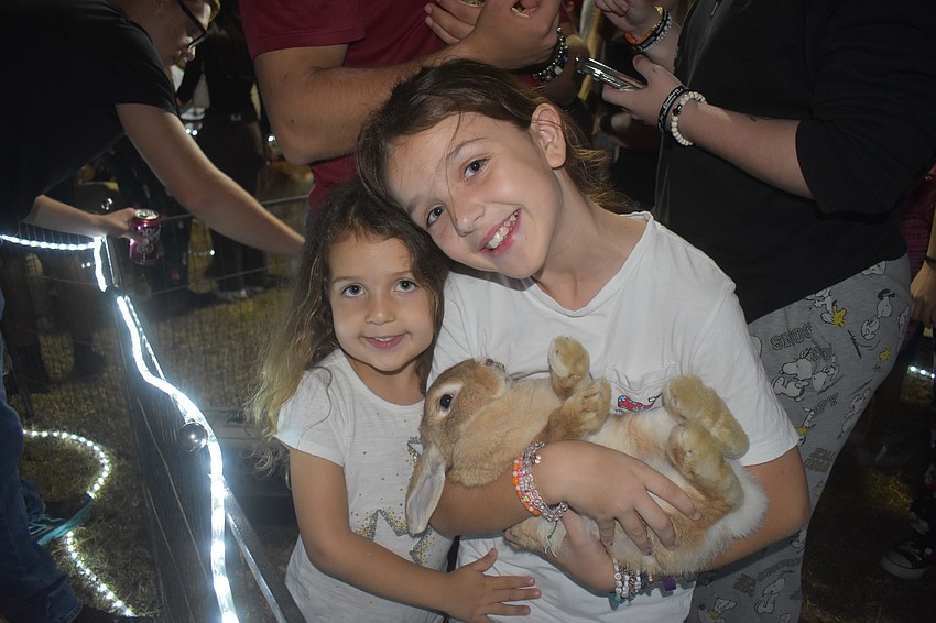 Creekwood's 4-year-old Peyton and 11-year-old Paige Jessop are eager to give cuddles to a bunny in the RCC Farm Experience petting zoo.