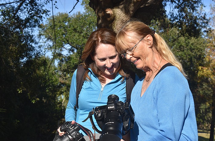 Lynnette Beecher and Gunilla Imshaug, members of the Lakewood Ranch Digital Photography Club, check out a photo of a baby alligator that was taken moments before.