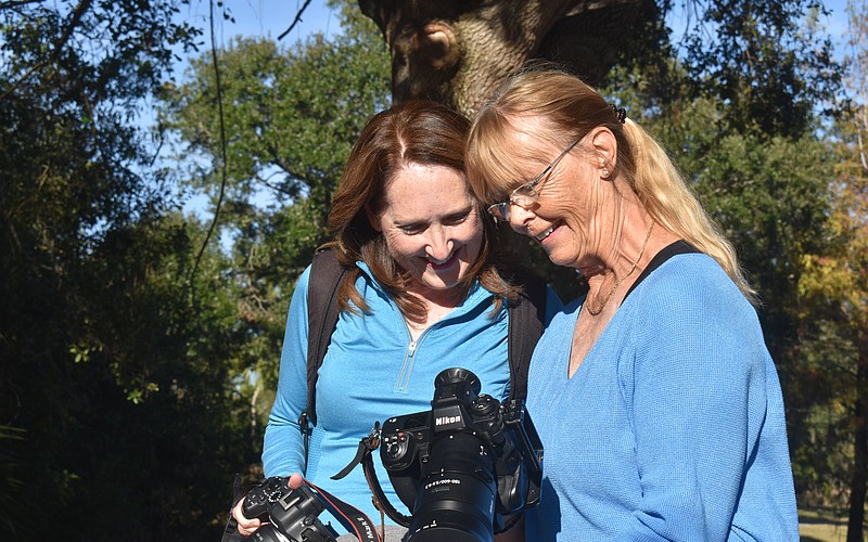 Lynnette Beecher and Gunilla Imshaug, members of the Lakewood Ranch Digital Photography Club, check out a photo of a baby alligator that was taken moments before.