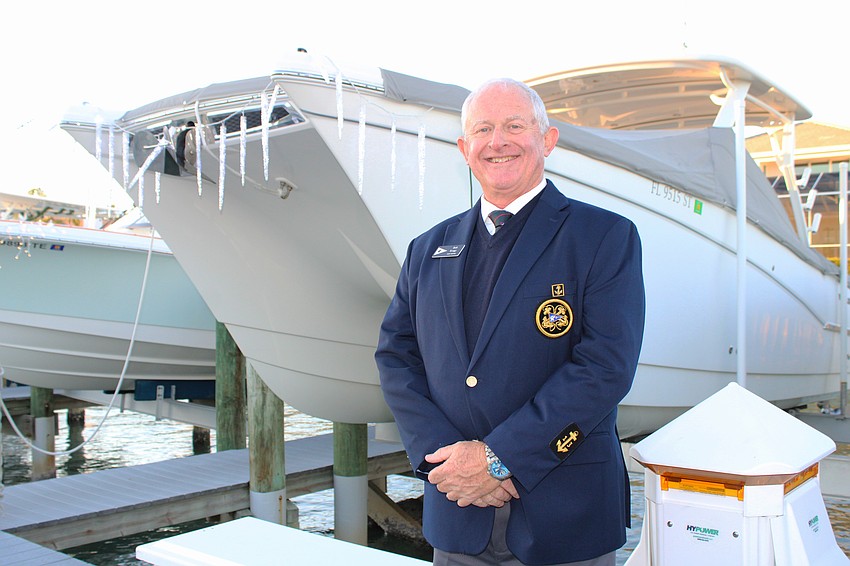 Bird Key Yacht Club Fleet Captain Bob Keagy stands with his icicle-laden boat at the Blessing and Lighting of the Fleet.