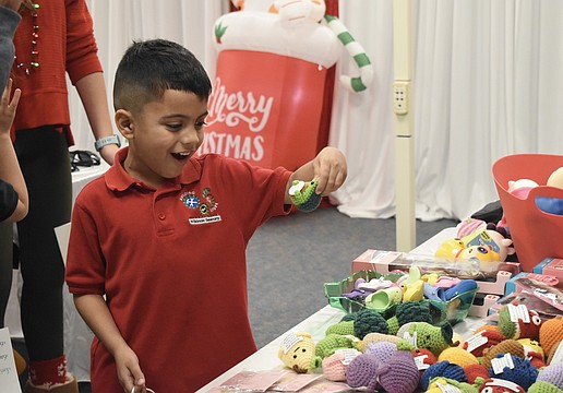 Kindergartener Santiago Perez checks out the crochet items.