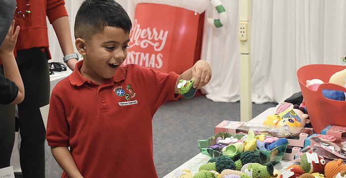 Kindergartener Santiago Perez checks out the crochet items.